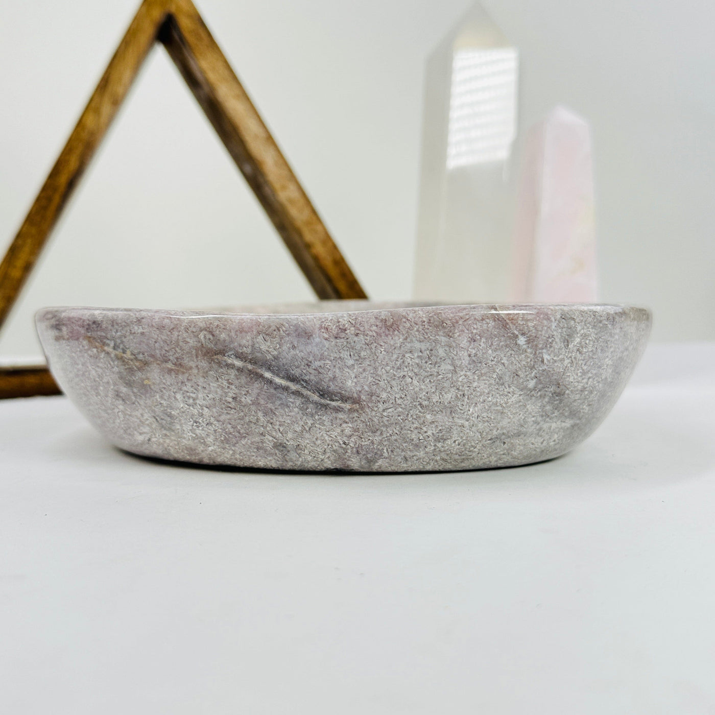 side view of pink amethyst bowl with decorations in the background