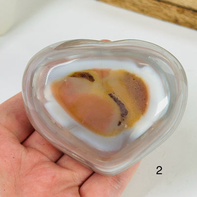 angel aura agate heart with decorations in the background