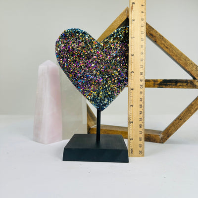 titanium coated heart on stand with decorations in the background