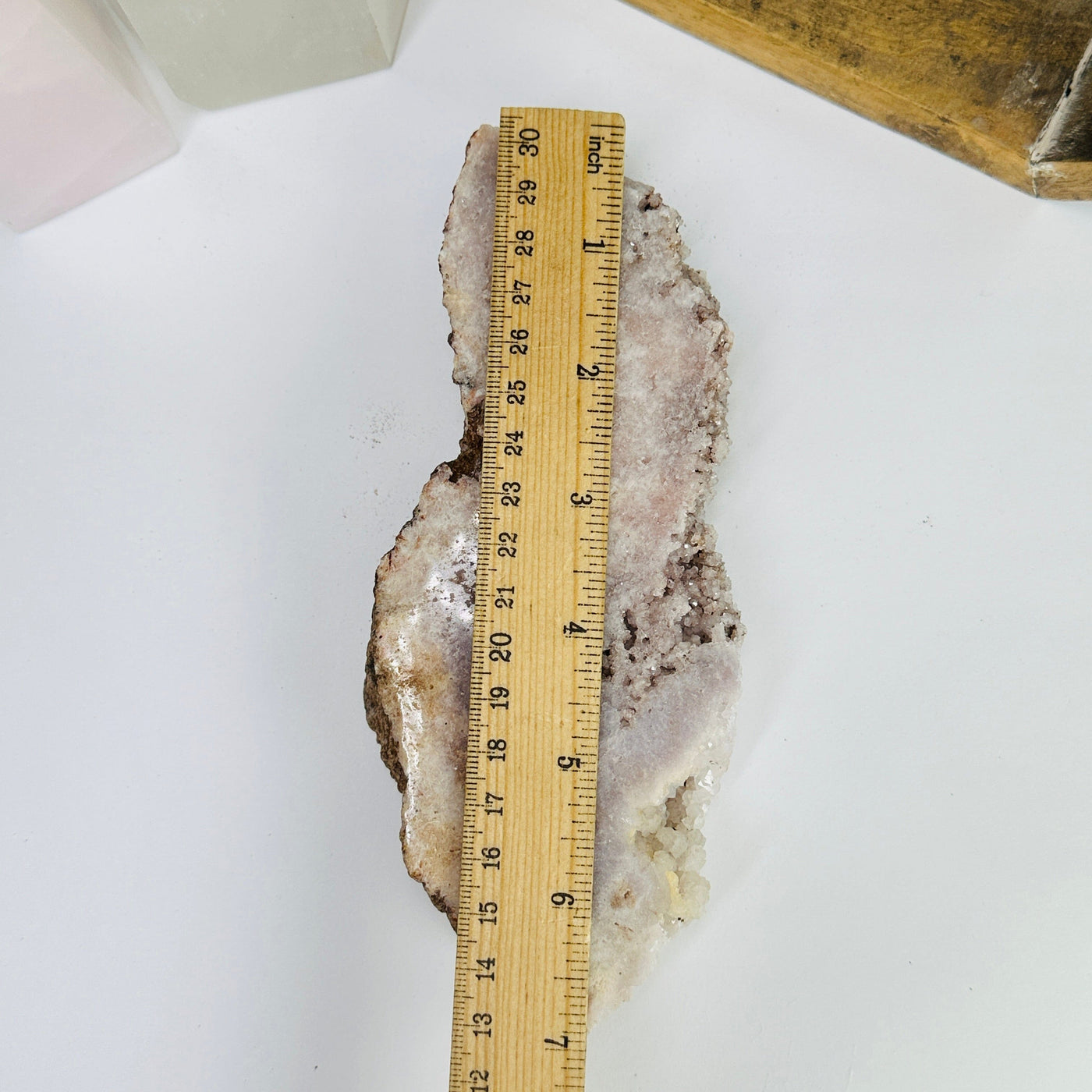 pink amethyst slab next to a ruler for size reference