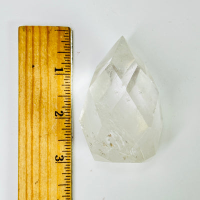 crystal quartz point next to a ruler for size reference