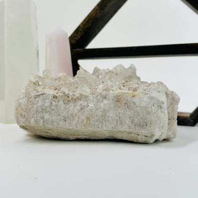 crystal quartz cluster with decorations in the background