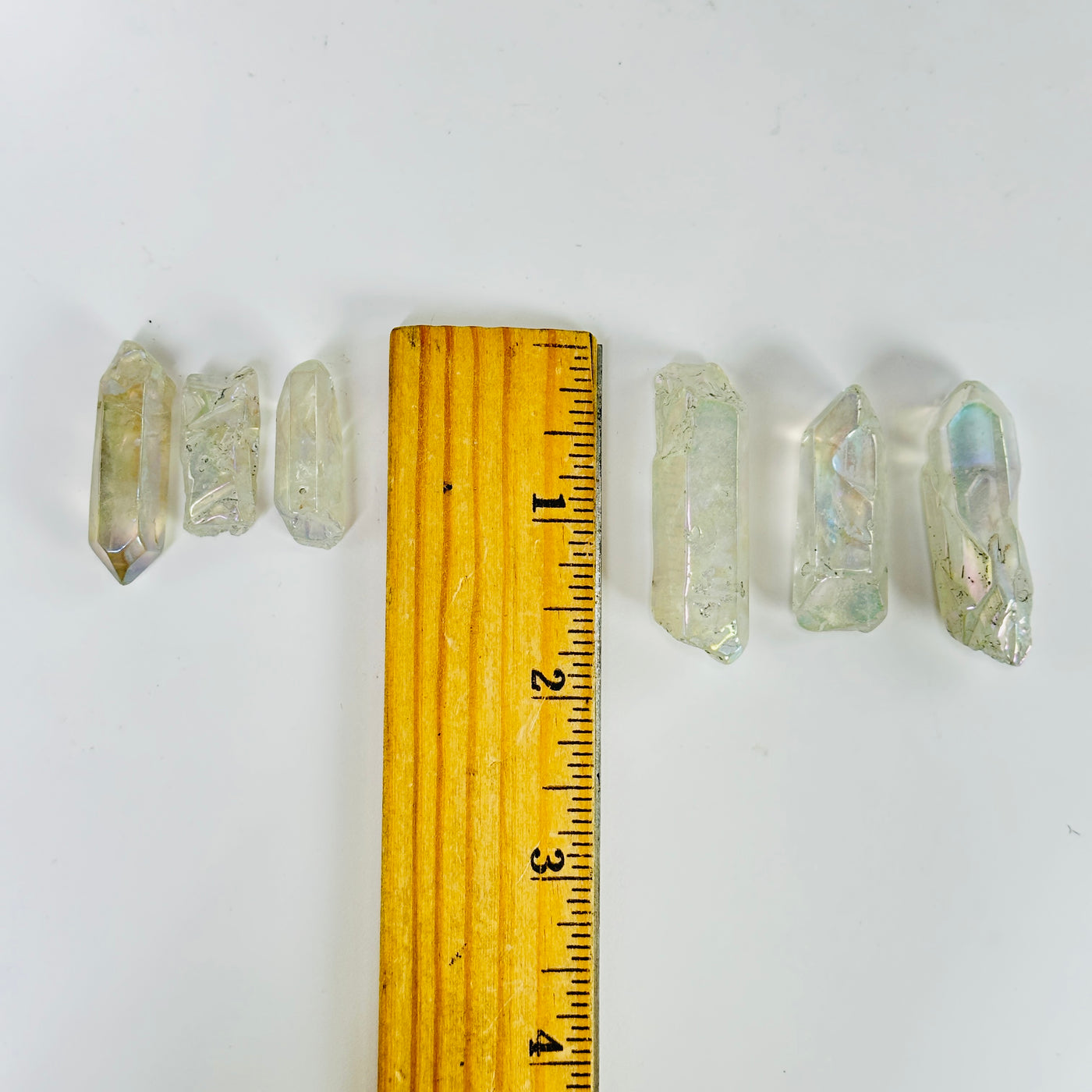 aura quartz crystal next to a ruler for size reference