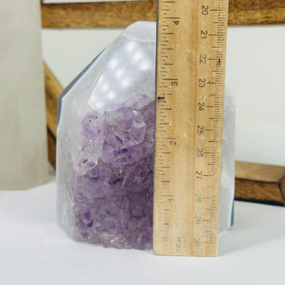 amethyst point next to a ruler for size reference