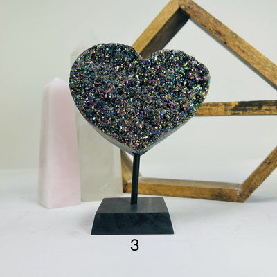 titanium coated heart on stand with decorations in the background