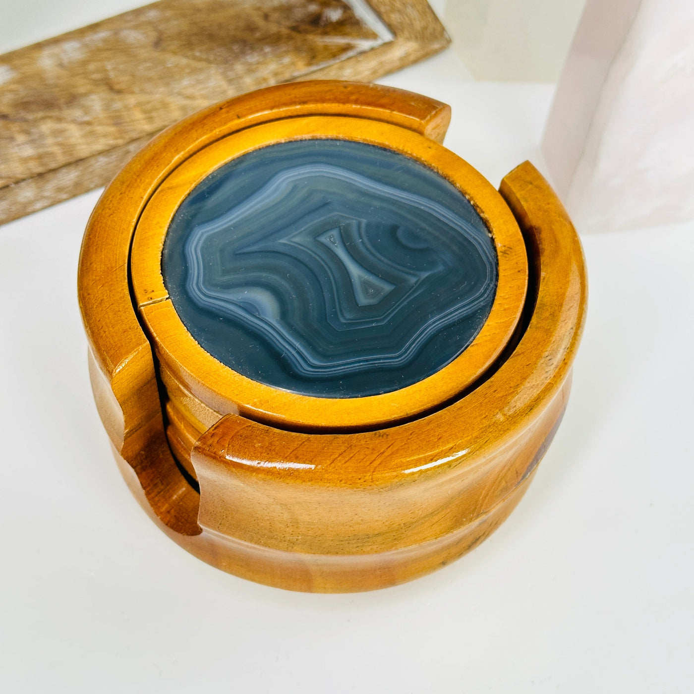 agate coasters in wooden container with decorations in the background