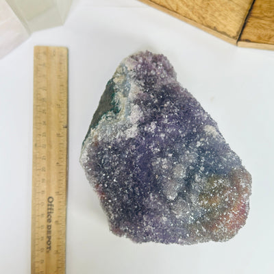 amethyst cluster next to a ruler for size reference