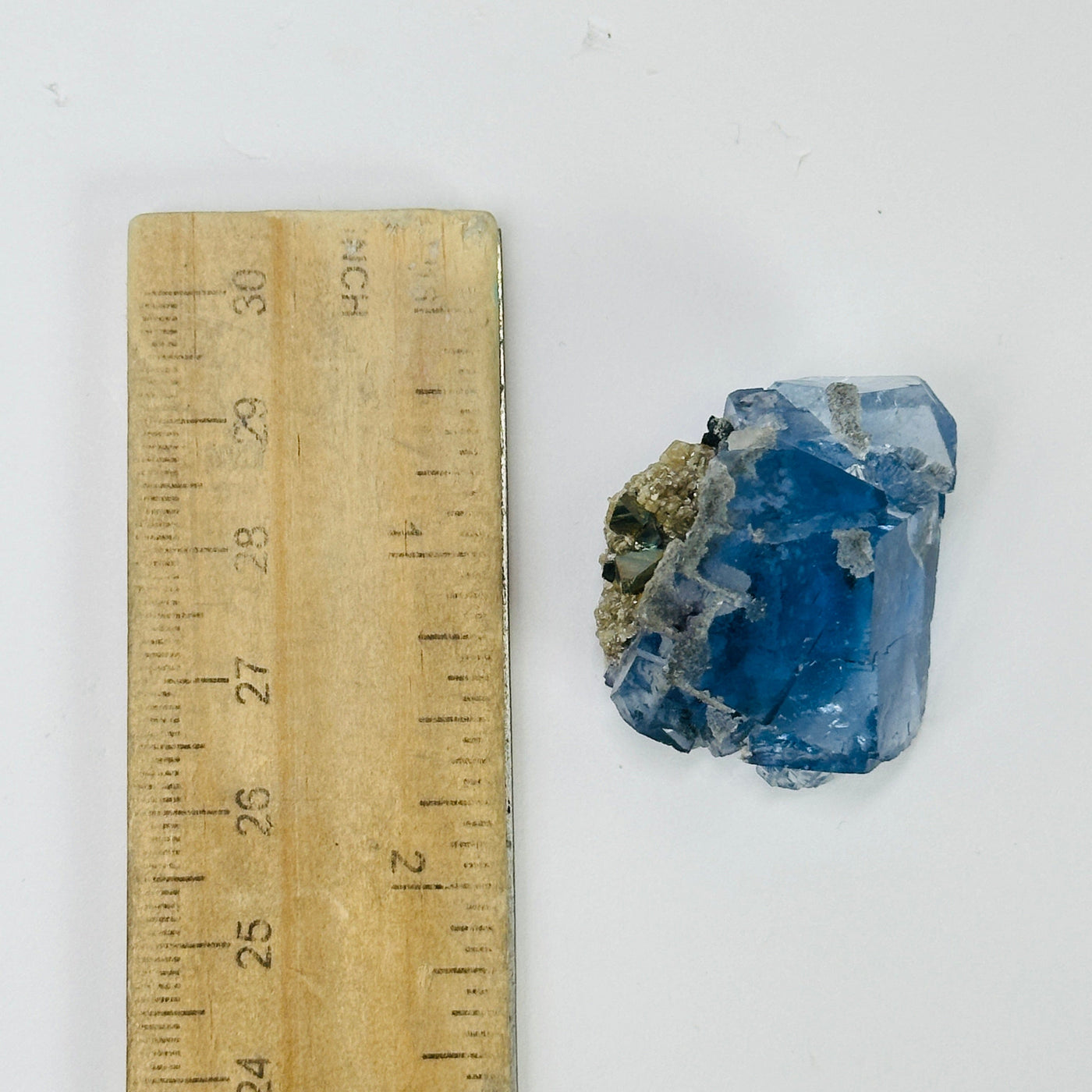 blue fluorite next to a ruler for size reference