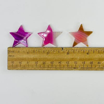 pink agate stars next to a ruler for size reference