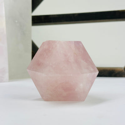 rose quartz dodecahedron with decorations in the background
