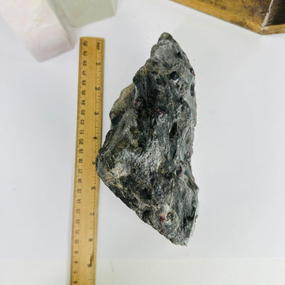 garnet on hematite next to a ruler for size reference