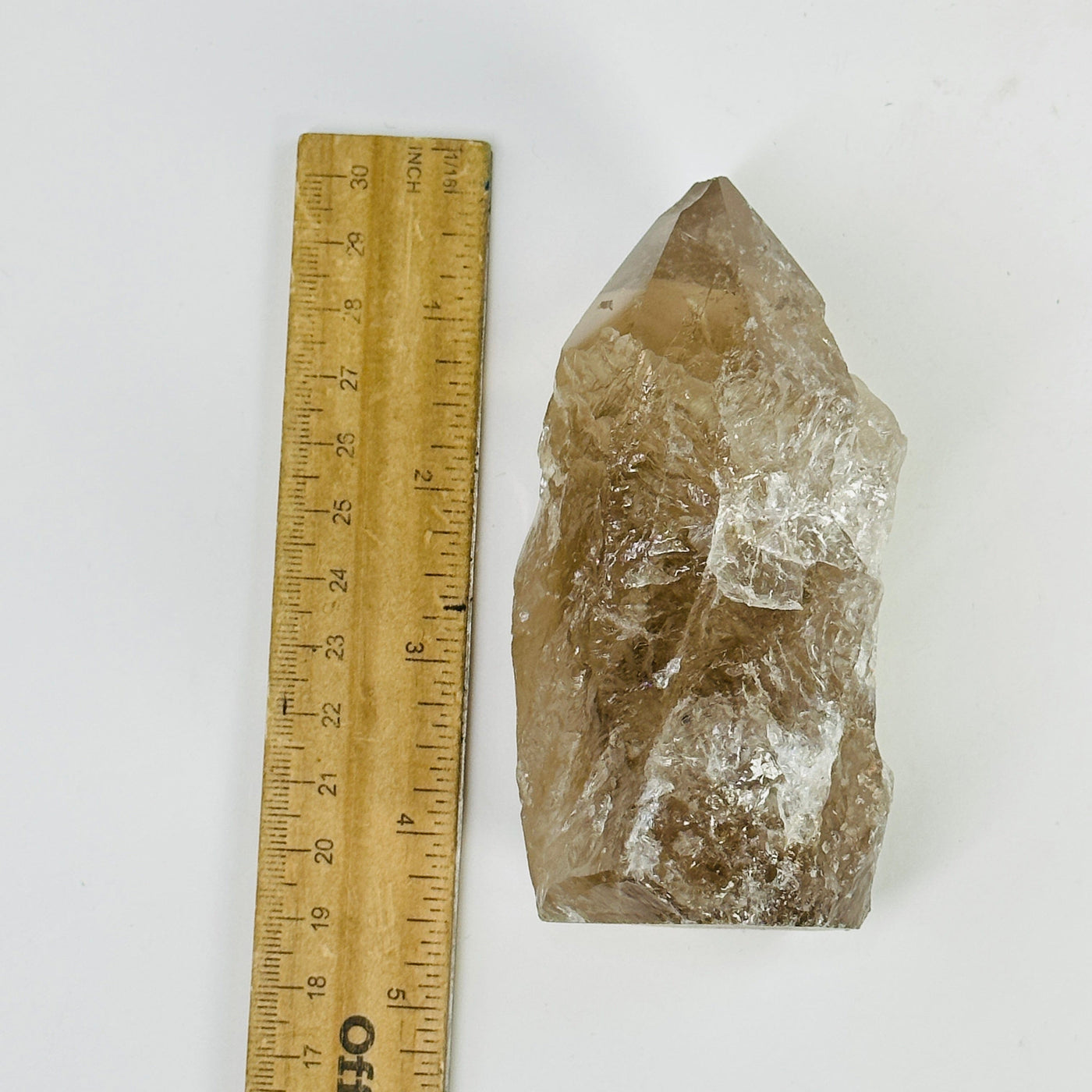 smoky quartz semi polished point next to a ruler for size reference