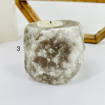 HIMALAYAN SALT CANDLE HOLDER WITH DECORATIONS IN THE BACKGROUND