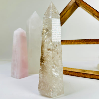 crystal quartz point with decorations in the background