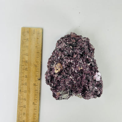 lepidolite cluster next to a ruler for size reference