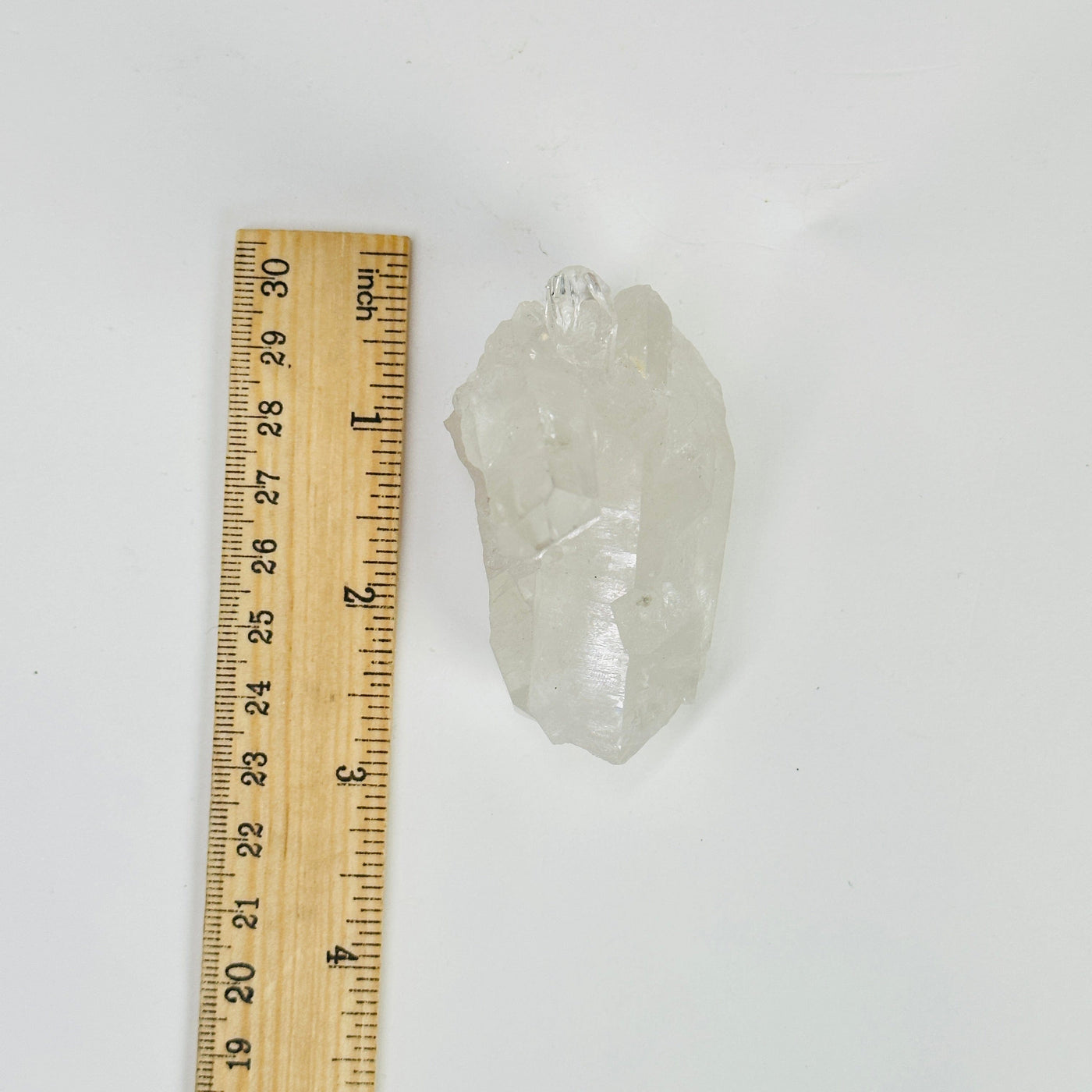 crystal quartz cluster next to a ruler for size reference
