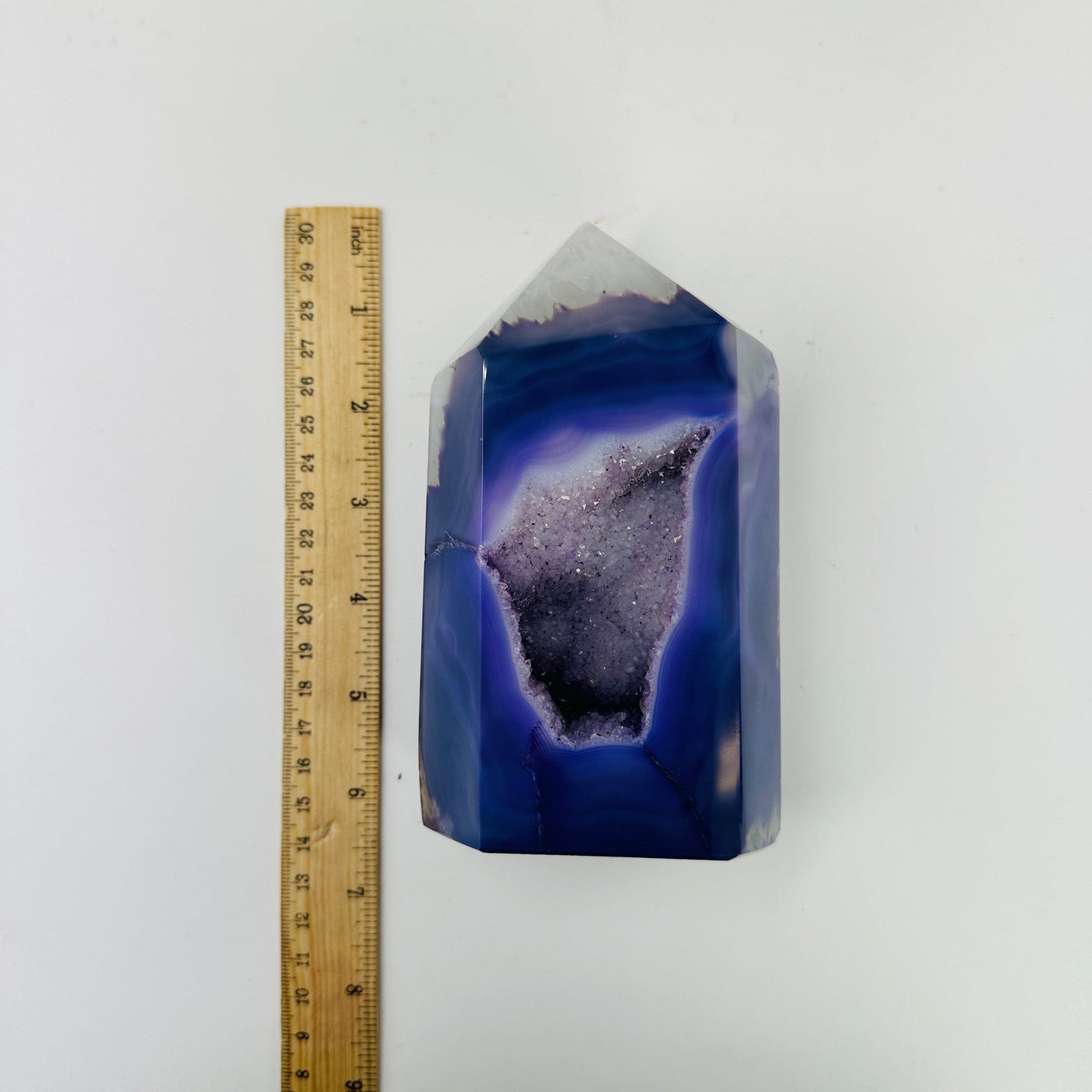 purple agate point next to a ruler for size reference