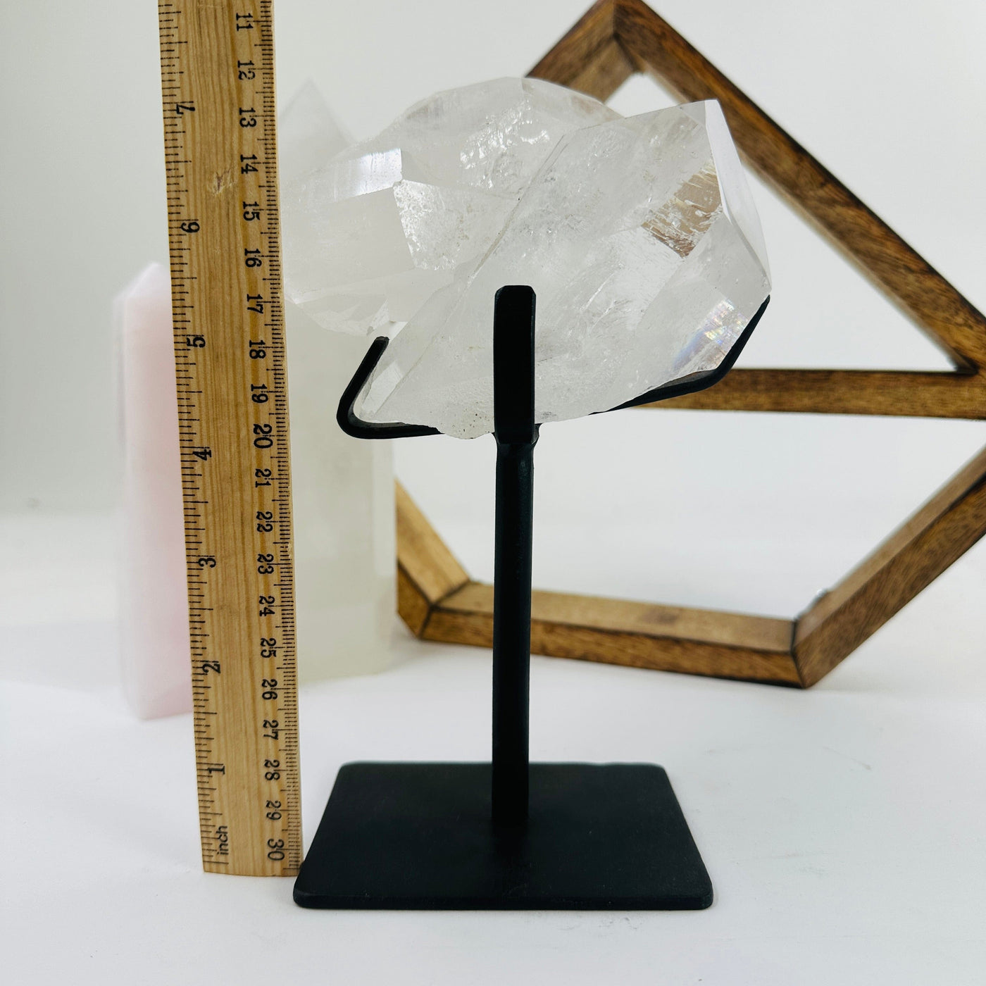 crystal quartz on metal stand next to a ruler for size reference