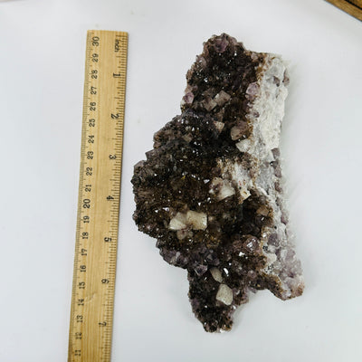 amethyst cluster next to a ruler for size reference