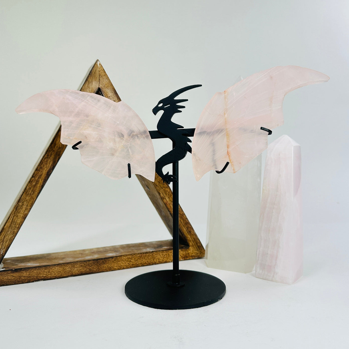 rose quartz dragon on metal stand with decorations in the background