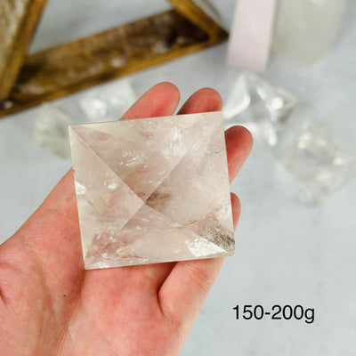 hand holding up 150-200g crystal quartz shape