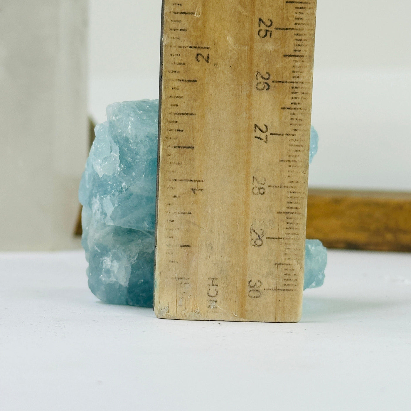 aquamarine stone next to a ruler for size reference