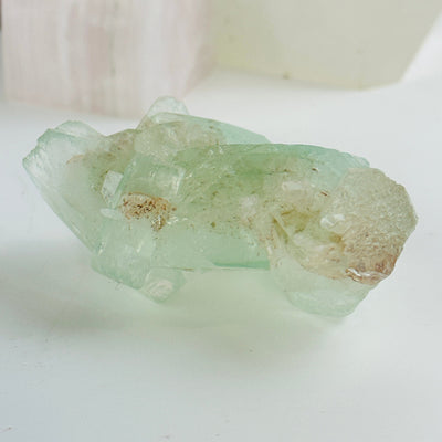 green apophyllite with stilbite cluster with decorations in the background