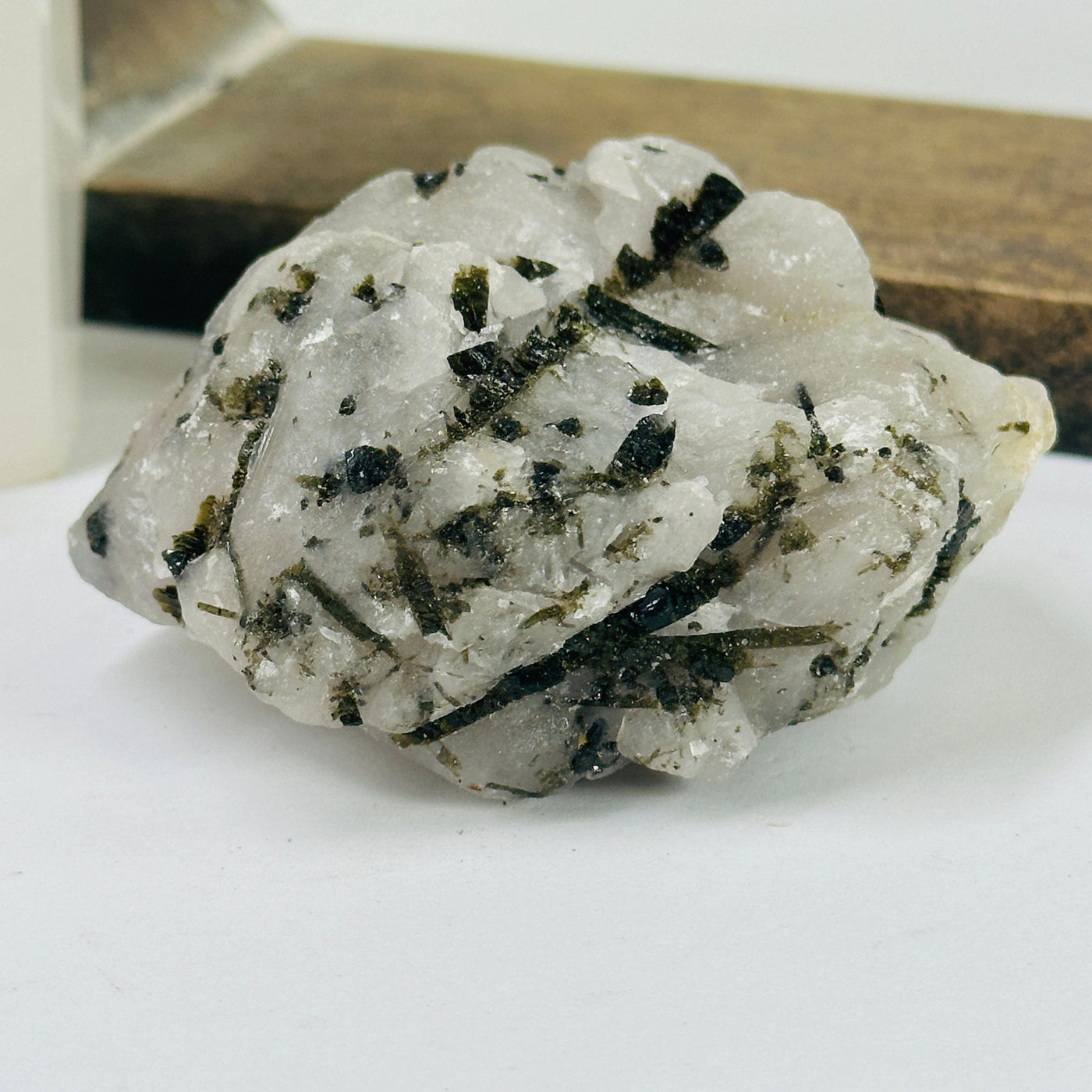 epidote on matrix with decorations in the background