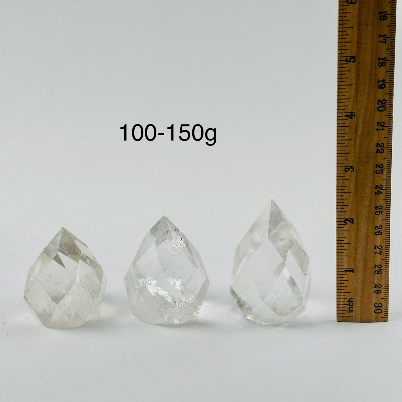 Crystal Quartz Faceted Egg Point - By Weight 100-150g variants next to ruler for size reference