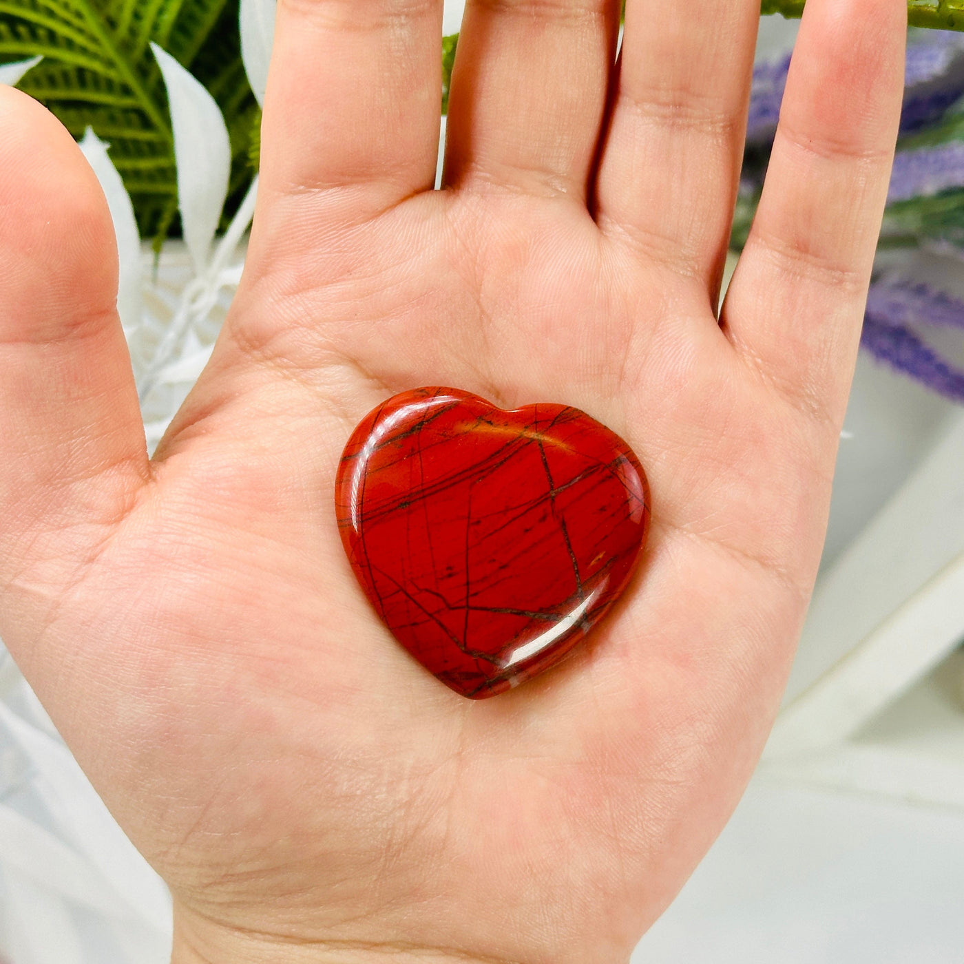 Red Jasper Polished Heart in hand for size reference