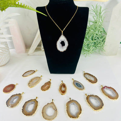 Agate Slice - Gold Electroplated Pendant with Gold Bail - You Choose pendant 7 on necklace on necklace stand surrounded other agate pendants