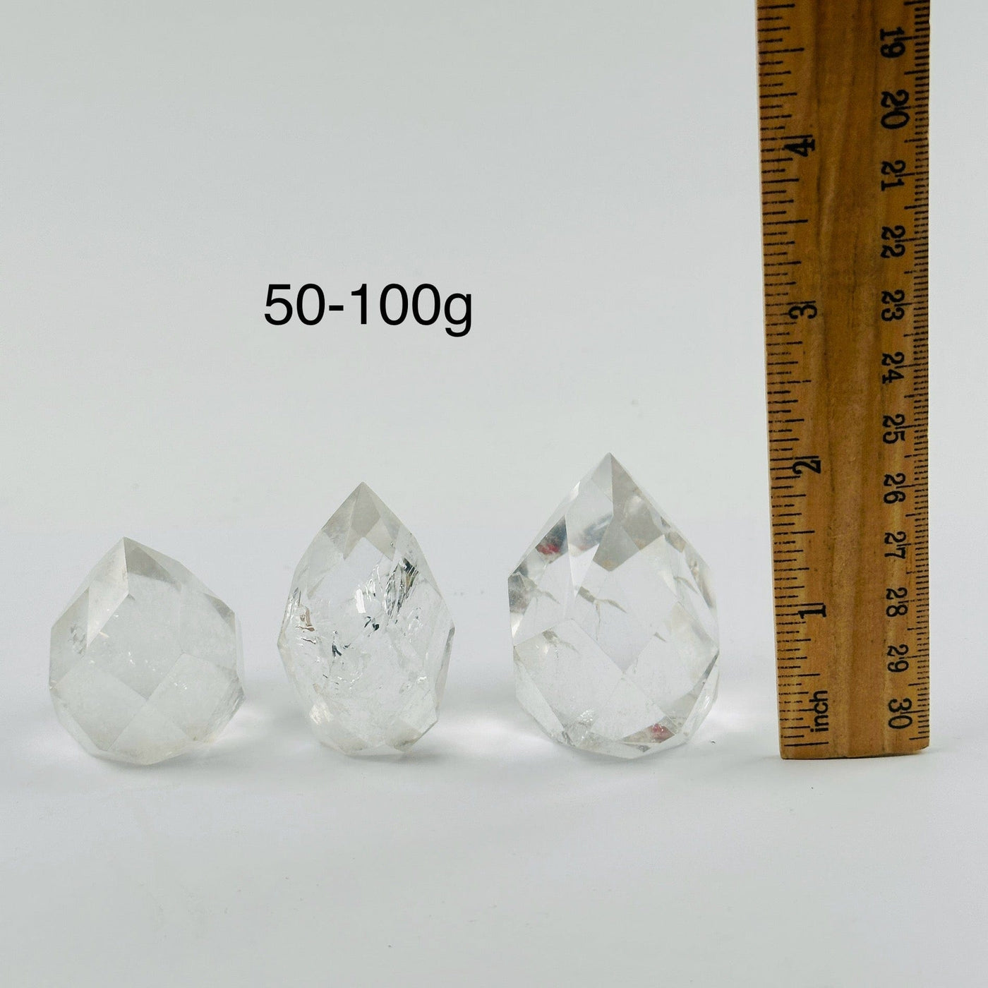 Crystal Quartz Faceted Egg Point - By Weight 50-100g variants next to ruler for size reference