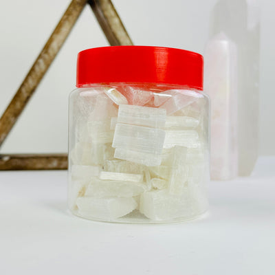 selenite in plastic jar with decorations in the background