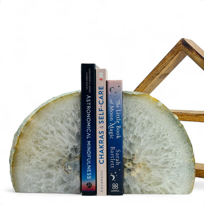 Large Agate Bookend with three books in between in front of a wood shelf with a white background.