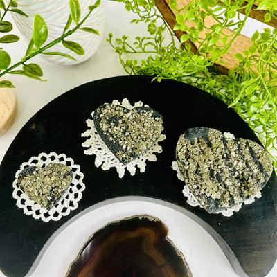 Pyrite on Basalt Hearts - By Weight hearts displayed as home decor on doilies on black moon tray with plants and props in background