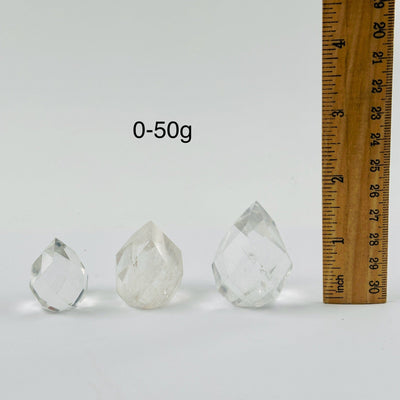 Crystal Quartz Faceted Egg Point - By Weight 0-50g variants next to ruler for size reference