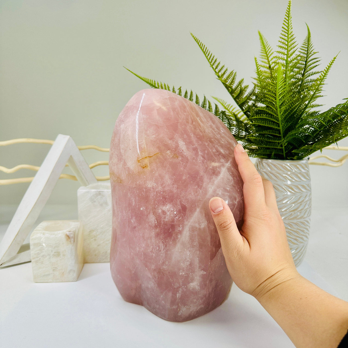 Rose Quartz Freeform Cut Base Crystal with hand for size reference