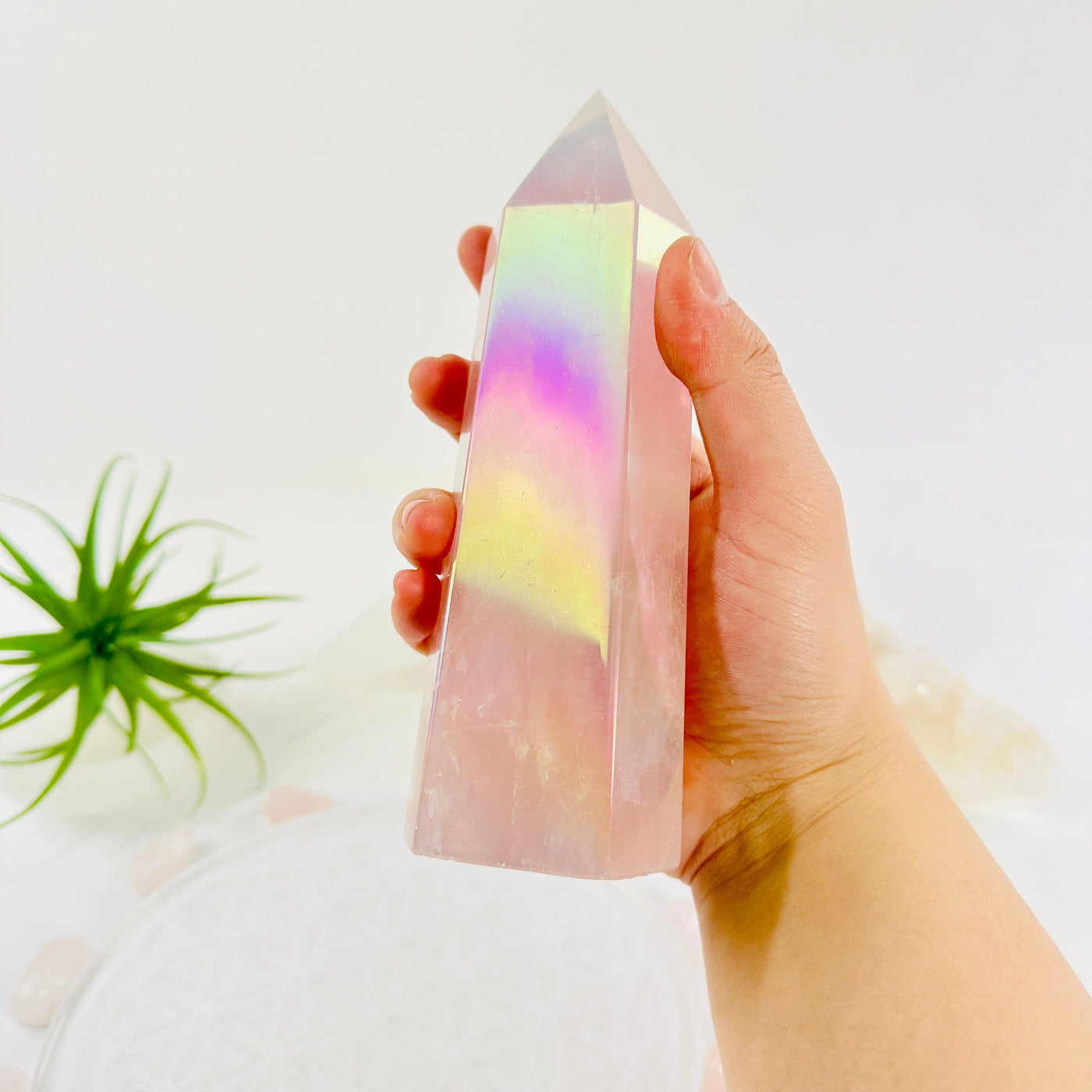 Angel Aura Rose Quartz Generator in hand for size reference