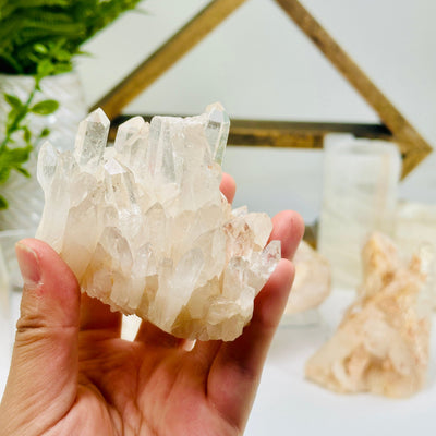 Lemurian Tangerine Quartz Crystal Cluster - You Choose cluster B in hand with other clusters in background