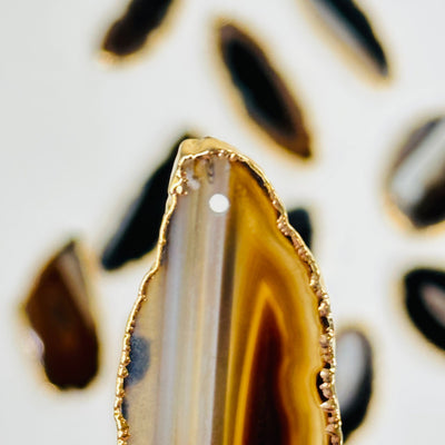 up close shot of brown agate slice showing drilled hole