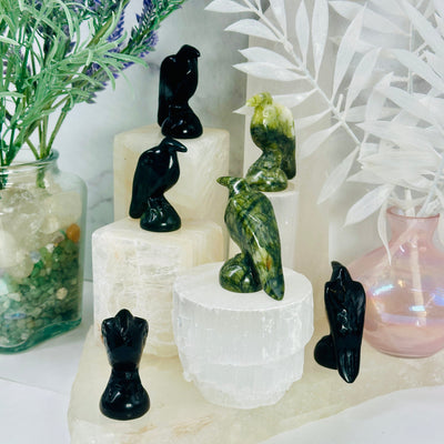 Gemstone Raven - Carved Raven - black obsidian and green jadeite ravens on white pedestals of different heights at different angles to show detail
