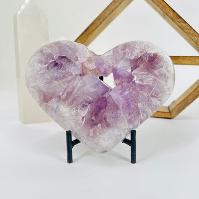 amethyst heart with stand with decorations in the background