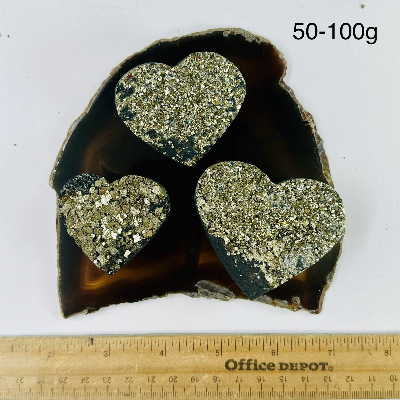 Pyrite on Basalt Hearts - By Weight 50-100g variants on dark agate slice with ruler for size reference