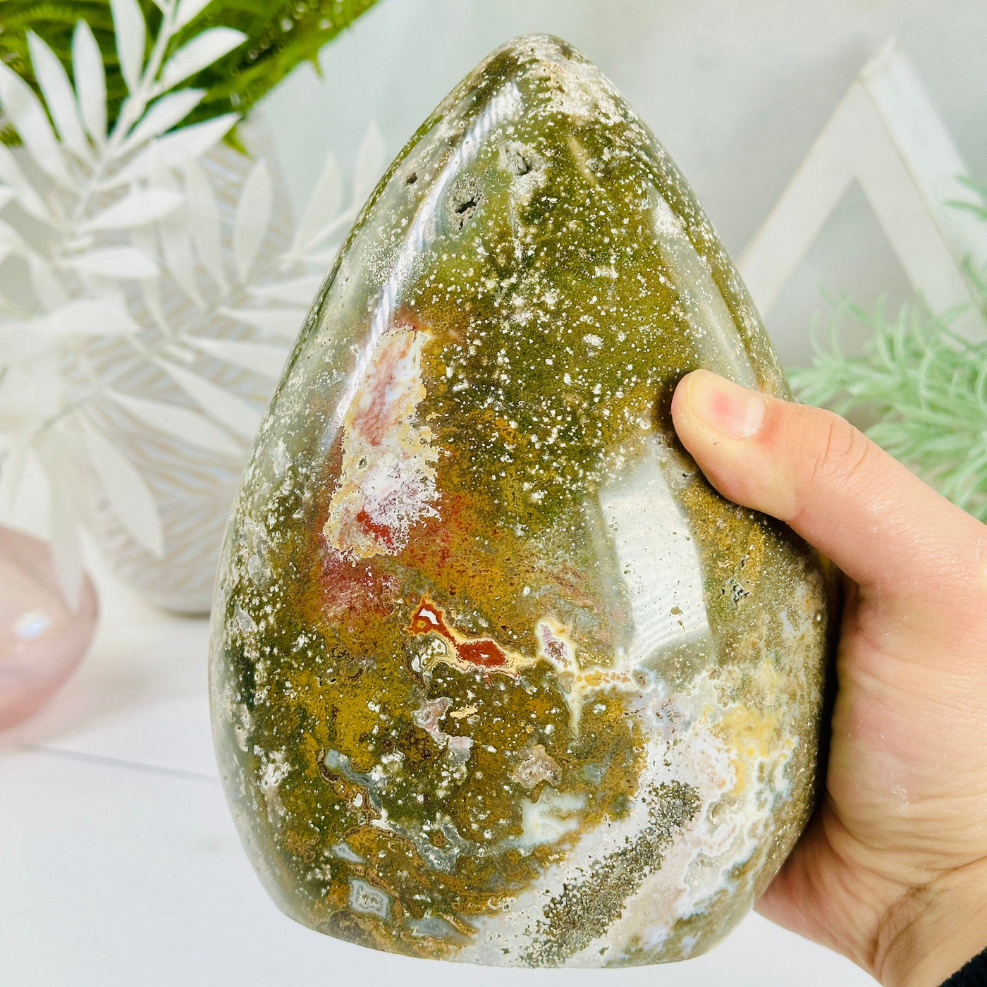 Ocean Jasper Polished Crystal Cut Base with hand for size reference