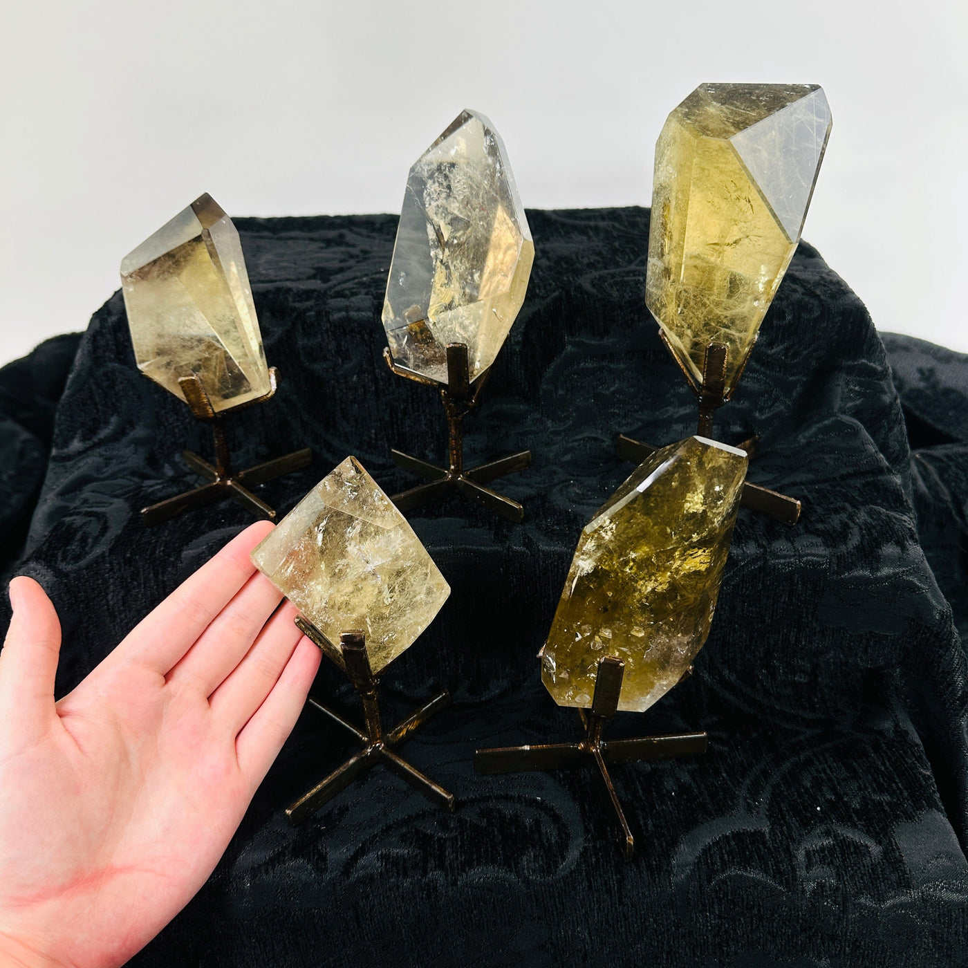 hand next to citrine on metal stand with others in the background