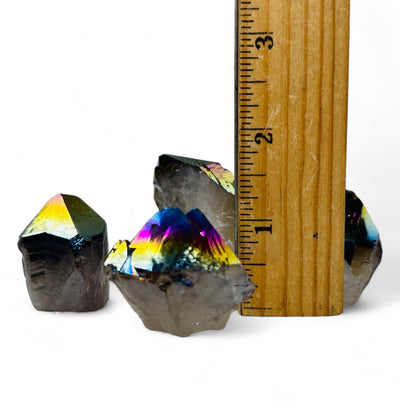 Rainbow Titanium Coated Crystal Quartz Points next to a ruler for size reference.