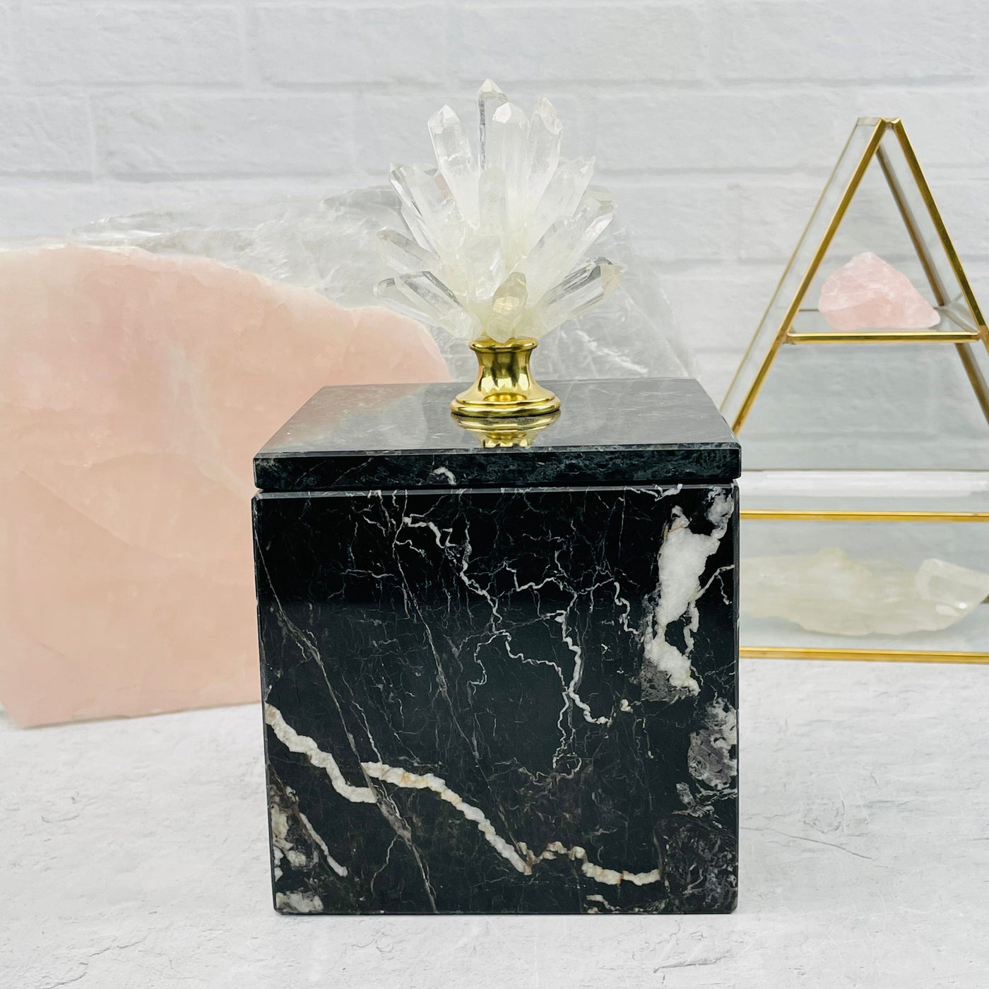  crystal point pinecone on marble box with decorations in the background