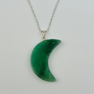 close up of a moon crescent pendant on a necklace chain to show how it hangs