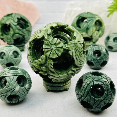 multiple Carved Jade Puzzle Balls displayed to show the differences in the sizes and color shades 