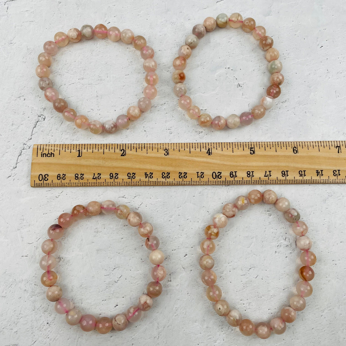 bracelets next to a ruler for size reference 